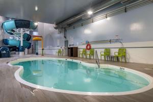 una gran piscina en un gimnasio con sillas verdes en Best Western Plus Dartmouth Hotel & Suites, en Halifax