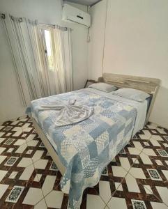 1 dormitorio con 1 cama con edredón azul y blanco en Casa Dona Vilma, en Barreirinhas