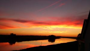 una puesta de sol sobre un río con el cielo en Pension Remenar & Lorenz, en Zeithain