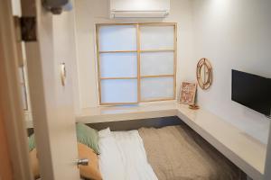 Zimmer mit Fenster, Bett und TV in der Unterkunft ビジネスホテル韓国館 in Tokio