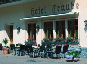 un gruppo di tavoli e sedie all'esterno di un ristorante di Moselhotel & Restaurant Zur Traube GmbH a Löf