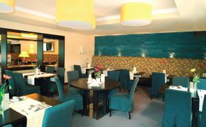 una sala da pranzo con tavoli e sedie blu di Moselhotel & Restaurant Zur Traube GmbH a Löf