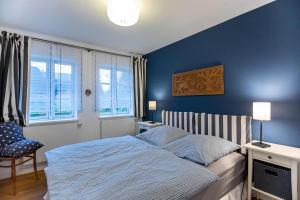 a bedroom with a bed and a blue wall at Ferienwohnung Abelke in Utersum