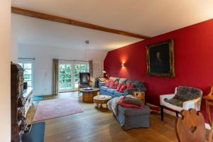 a living room with a red wall at Ferienwohnung Abelke in Utersum