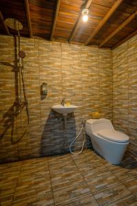 a bathroom with a toilet and a sink at The Tetamian Bali in Sukawati