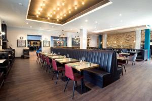 ein Restaurant mit Tischen und Stühlen und eine Bar in der Unterkunft Sandman Signature London Gatwick Hotel in Crawley