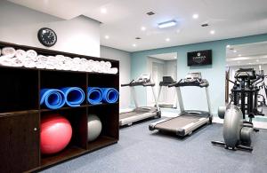 einen Fitnessraum mit Laufbändern und Trainingsgeräten in einem Zimmer in der Unterkunft Sandman Signature London Gatwick Hotel in Crawley