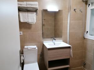 y baño con lavabo, aseo y espejo. en Apartamentos Regollera Premium con garaje, en Noja