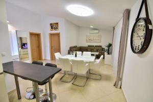 une salle à manger avec une table et une horloge murale dans l'établissement Apartments Sana 2, à Vir