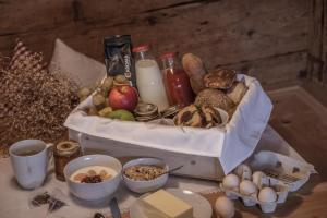 una mesa cubierta con una cesta de pan y huevos en Ciasa Somuer - Sorà, en San Vigilio Di Marebbe