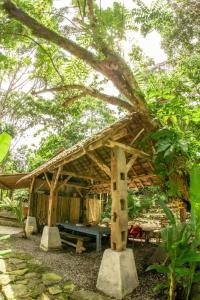 eine Holzhütte mit einem Tisch und einem Baum in der Unterkunft Villa Kampung Ayem Riverside in Sleman