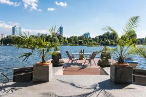 Elle offre une vue sur un lac avec des chaises et des palmiers. dans l'établissement AJO Vienna Beach - Contactless Check-in, à Vienne