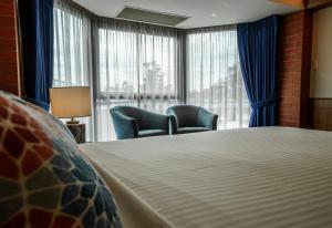 una camera con un letto e due sedie e una finestra di Arkaba Hotel a Adelaide