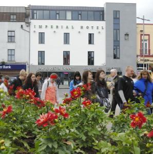 a group of people walking in front of a building at Imperial Hotel Galway in Galway