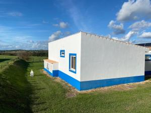 un pequeño edificio blanco y azul en un campo en Casa Bendi, en Cuba