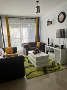 ein Wohnzimmer mit einem Sofa und einem Couchtisch in der Unterkunft Zoe Homes Greypoint 1br and 2br Apartment 101 in Kericho