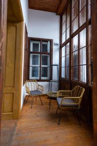 two chairs and a table in a room with windows at Althof Apartments in Sibiu