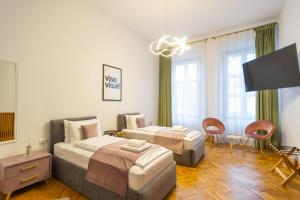 a hotel room with two beds and a flat screen tv at Althof Apartments in Sibiu