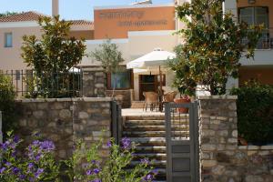 une maison avec une porte dans un jardin fleuri dans l'établissement Harmony Hotel Apartments, à Selianitika