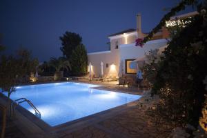 - une piscine en face de la villa la nuit dans l'établissement Harmony Hotel Apartments, à Selianitika