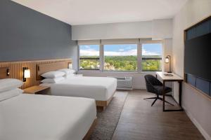 een hotelkamer met 2 bedden, een bureau en een raam bij Hyatt Regency Morristown in Morristown