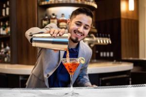 een man die een drankje in een glas giet bij Hyatt Regency Morristown in Morristown