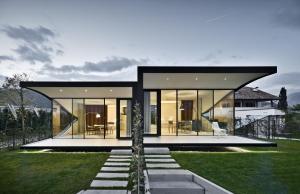 uma casa com um telhado preto e um jardim em Mirror Houses em Bolzano