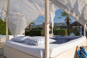 a canopy bed with pillows on a balcony at TUI BLUE Kalamota Island - Adults Only in Dubrovnik