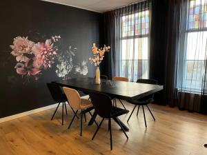 una mesa de comedor negra con sillas y un jarrón con flores en Appartement centrum Leeuwarden, en Leeuwarden