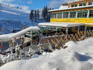 un edificio con nieve en el suelo delante de él en Gasthof Klug zum Ehrensepp, en Modriach