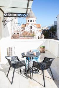 d'un balcon sur le toit avec une table et des chaises. dans l'établissement Aθens Dome - Apartments by Live&Travel, à Athènes