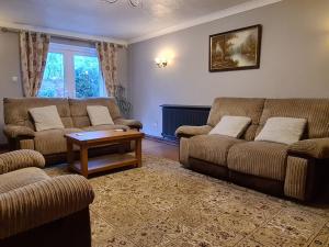 un soggiorno con 2 divani e un tavolo di Spacious, 5 bed house for 9 in Chester a Chester