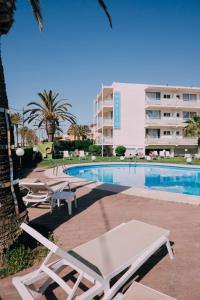 uma piscina com espreguiçadeiras e um edifício em Hotel Subur Maritim em Sitges