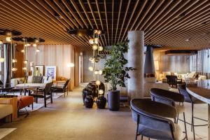 ein Restaurant mit Stühlen und Tischen sowie eine Lobby in der Unterkunft Altapura Hôtel & Spa Val Thorens in Val Thorens