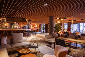 eine Lobby eines Hotels mit Sofas und einer Bar in der Unterkunft Altapura Hôtel & Spa Val Thorens in Val Thorens