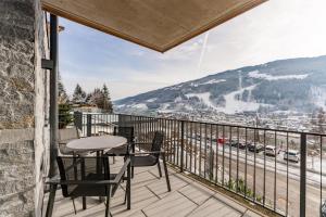 eine Terrasse mit einem Tisch und Stühlen auf dem Balkon in der Unterkunft Apartmentresort MyLodge in Schladming