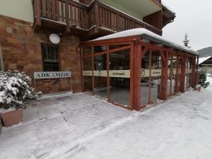 a building with glass doors in the snow at Aparmánový dom Kamzík,Apartmán 42,Donovaly in Donovaly