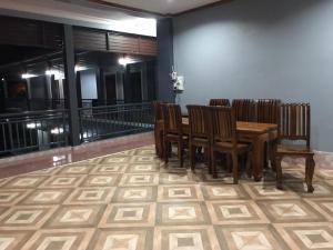 - une salle à manger avec une table et des chaises en bois dans l'établissement xaythone guest house, à Savannakhet