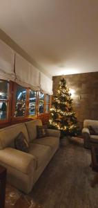 una sala de estar con un árbol de Navidad y un sofá en Hotel Fonfreda, en Vielha