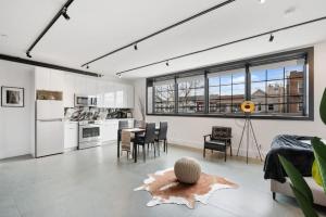 布鲁克林Deluxe Open Concept Loft with Rooftop & Shore Nearby at "Brooklyn Bay Lofts"的厨房以及带桌椅的起居室。