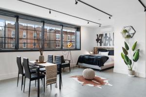 布鲁克林Deluxe Open Concept Loft with Rooftop & Shore Nearby at "Brooklyn Bay Lofts"的卧室配有一张床和一张桌子及椅子