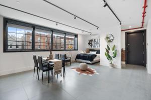 布鲁克林Deluxe Open Concept Loft with Rooftop & Shore Nearby at "Brooklyn Bay Lofts"的客厅配有桌椅和沙发