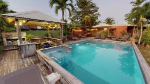 een groot zwembad in een achtertuin met een huis bij Baobab Guadeloupe in Sainte-Anne