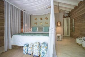 een slaapkamer met een hemelbed en een aantal stoelen bij Mahona Boutique Hotel in Las Terrenas