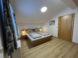 um pequeno quarto com uma cama e piso em madeira em apartment Eva in Wald im Pinzgau with balcony em Wald im Pinzgau