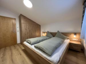 um quarto com uma cama grande e uma cabeceira em madeira em apartment Eva in Wald im Pinzgau with balcony em Wald im Pinzgau