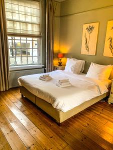 a bedroom with a bed with white sheets and a window at Hotel Beijers in Utrecht