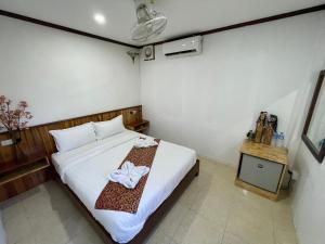 - une chambre avec un lit et une table avec des serviettes dans l'établissement Little Friendly Guest House and Swimming Pool, à Luang Prabang