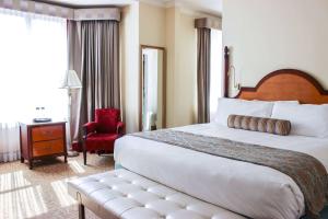 um quarto de hotel com uma cama grande e uma cadeira em Hotel Providence, Trademark Collection by Wyndham em Providence