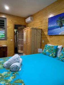 una camera da letto con un grande letto con lenzuola blu di TAMANU LODGE a Punaauia